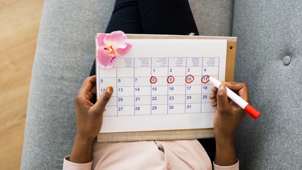 Femme notant son cycle menstruel sur un calendrier